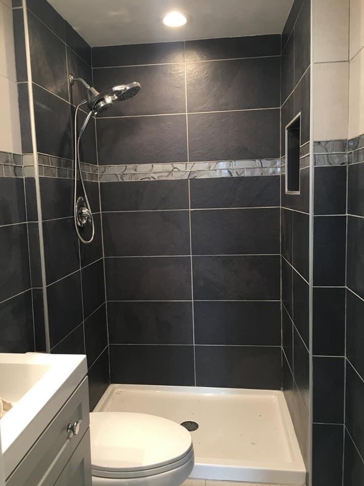 Bathroom with a dark tiled shower, vanity and toilet
