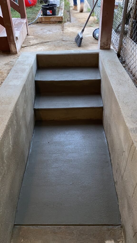 Concrete stairwell and retaining walls beside a building
