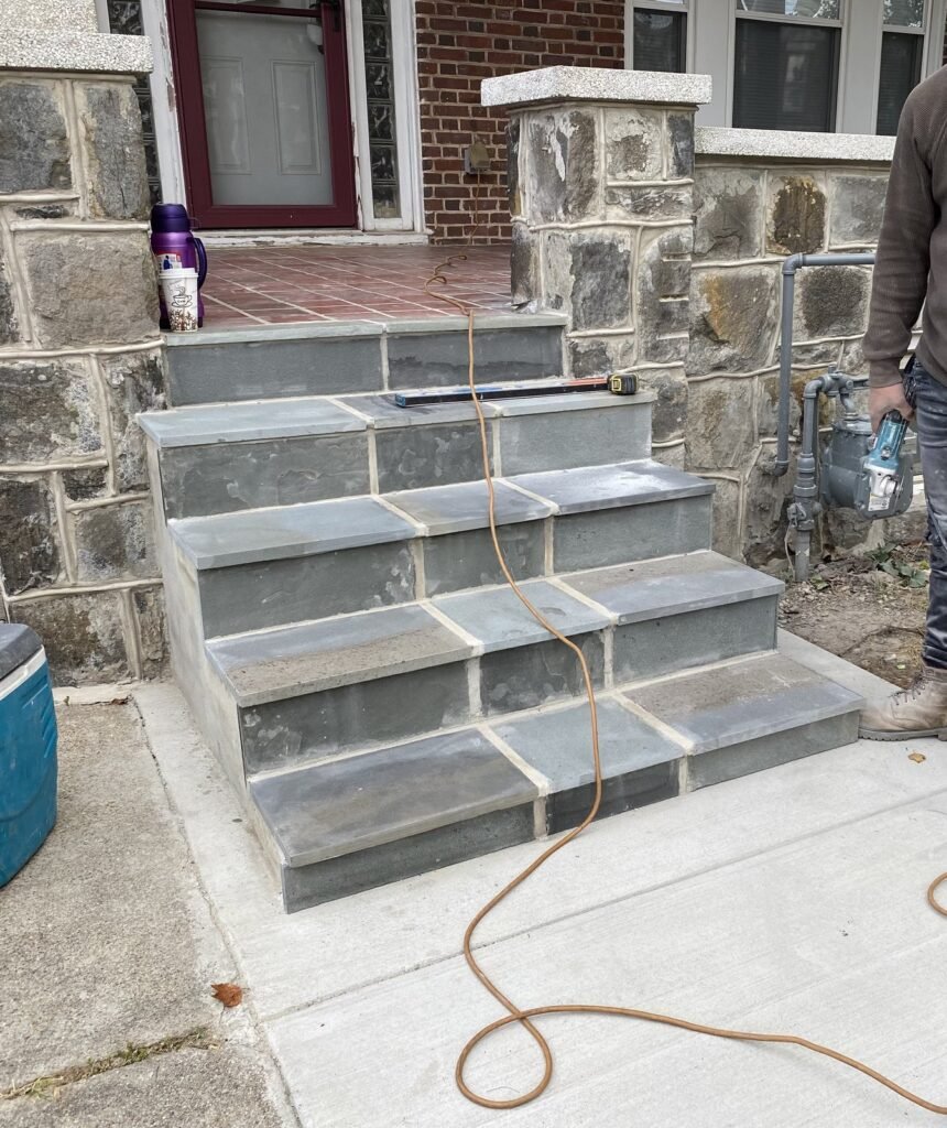 Exterior entry steps and landing beside a house