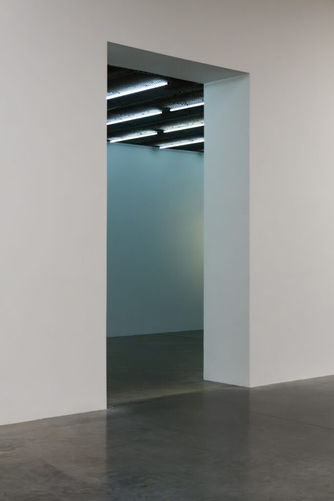 White interior walls and a doorway above a dark concrete floor